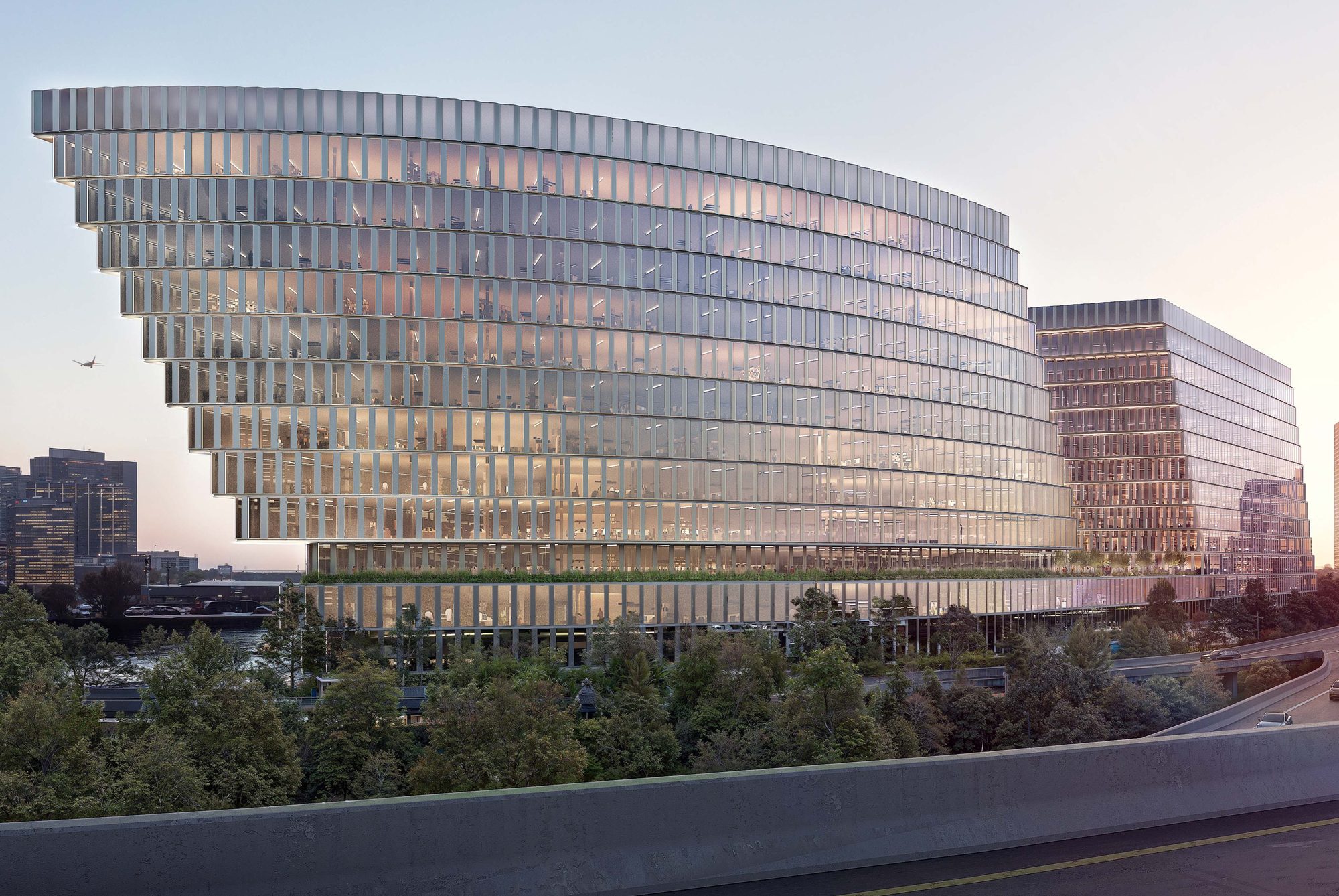 Curved glass office building at dusk